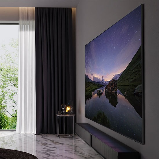 В гостиной в современном стиле сверхтонкий телевизор с изображением гор под звездным небом легко крепится на стену. Линия повторяет правильный профиль, подчеркивая изящный дизайн. Сверхтонкий телевизор элегантно вписывается в интерьер комнаты.