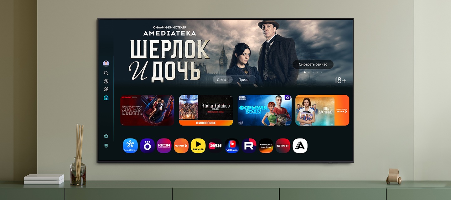 Домашний экран One UI Tizen с различными доступными приложениями и сервисами отображается на телевизоре в гостиной.