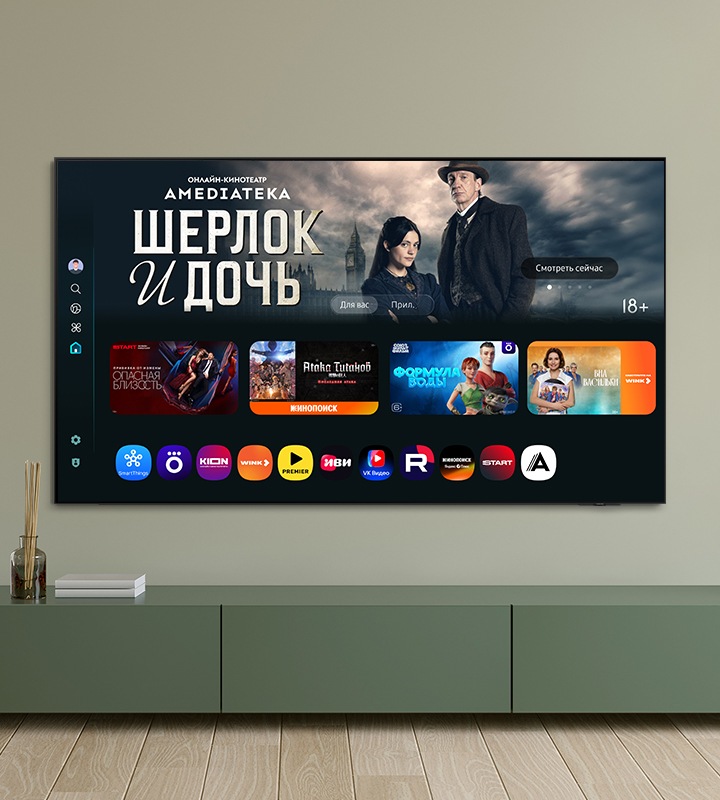 Домашний экран One UI Tizen с различными доступными приложениями и сервисами отображается на телевизоре в гостиной.