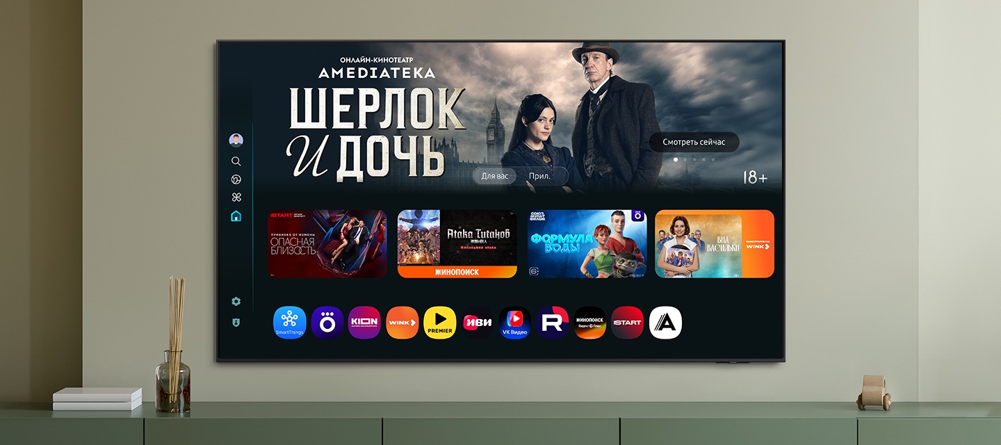 Домашний экран One UI Tizen с различными доступными приложениями и сервисами отображается на телевизоре в гостиной.