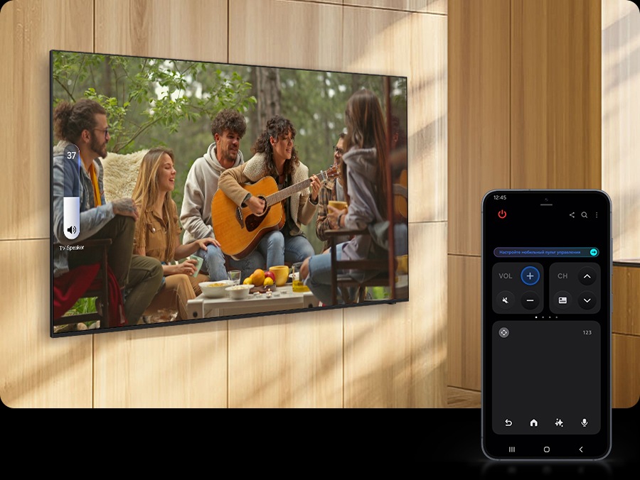 Смартфон Galaxy отображает режим Quick Remote, который используется для увеличения громкости ближайшего телевизора, показывающего сцену с женщиной, играющей на гитаре.