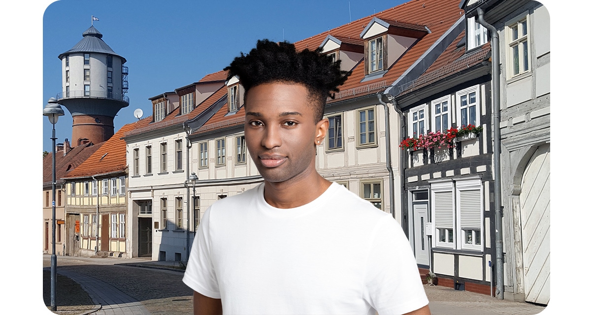 High quality portrait shot of a young man looking up, while the houses in the background are shown very clearly.