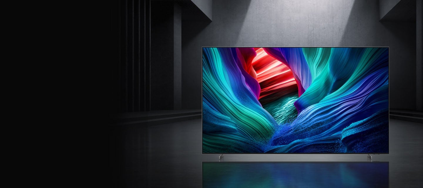 Микро-RGB-телевизор в серой комнате воспроизводит сцену с абстрактными цветами. Подпись гласит: &laquo;Первый в мире микро-RGB, почувствуйте силу цвета&raquo;.