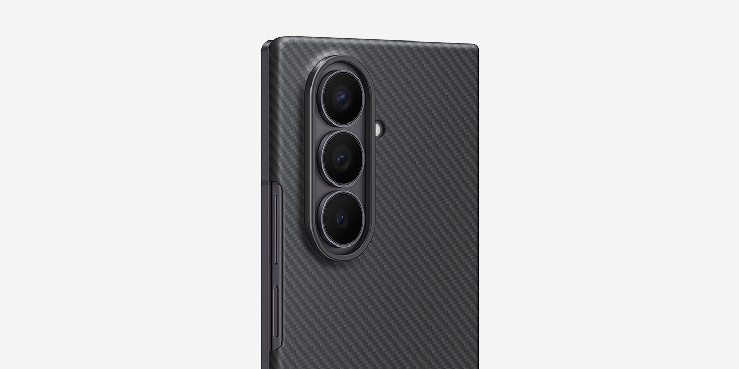 تظهر لقطة مقرّبة للهاتف طراز Galaxy Z Fold7، ويظهر فيها الغطاء الخلفي وهو متجه إلى الأمام بزاوية جانبية طفيفة. يظهر الهاتف طراز Galaxy Z Fold7 وهو مُحاط بالحافظة Carbon Shield Case بلون أسود، بحيث يتم إبراز نحافة الحافظة.