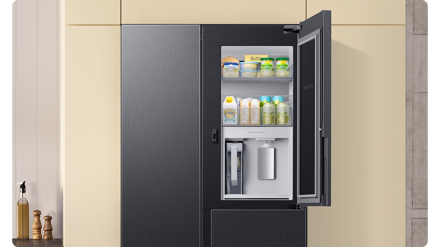 The camera zooms in to the Beverage Center inside the refrigerator door. A hand approaches with a cup, filling it with water from the water dispenser. Next to it is an AutoFill Water Pitcher. The water is filled up.