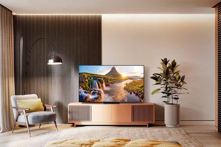 A Neo QLED TV is on display in a cozy bedroom-like environment.