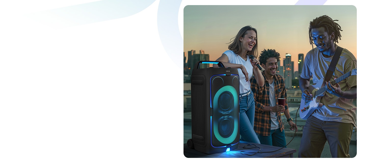 3 people outdoors are enjoying themselves. One person plays the guitar and one sings via microphone with the Sound Tower.