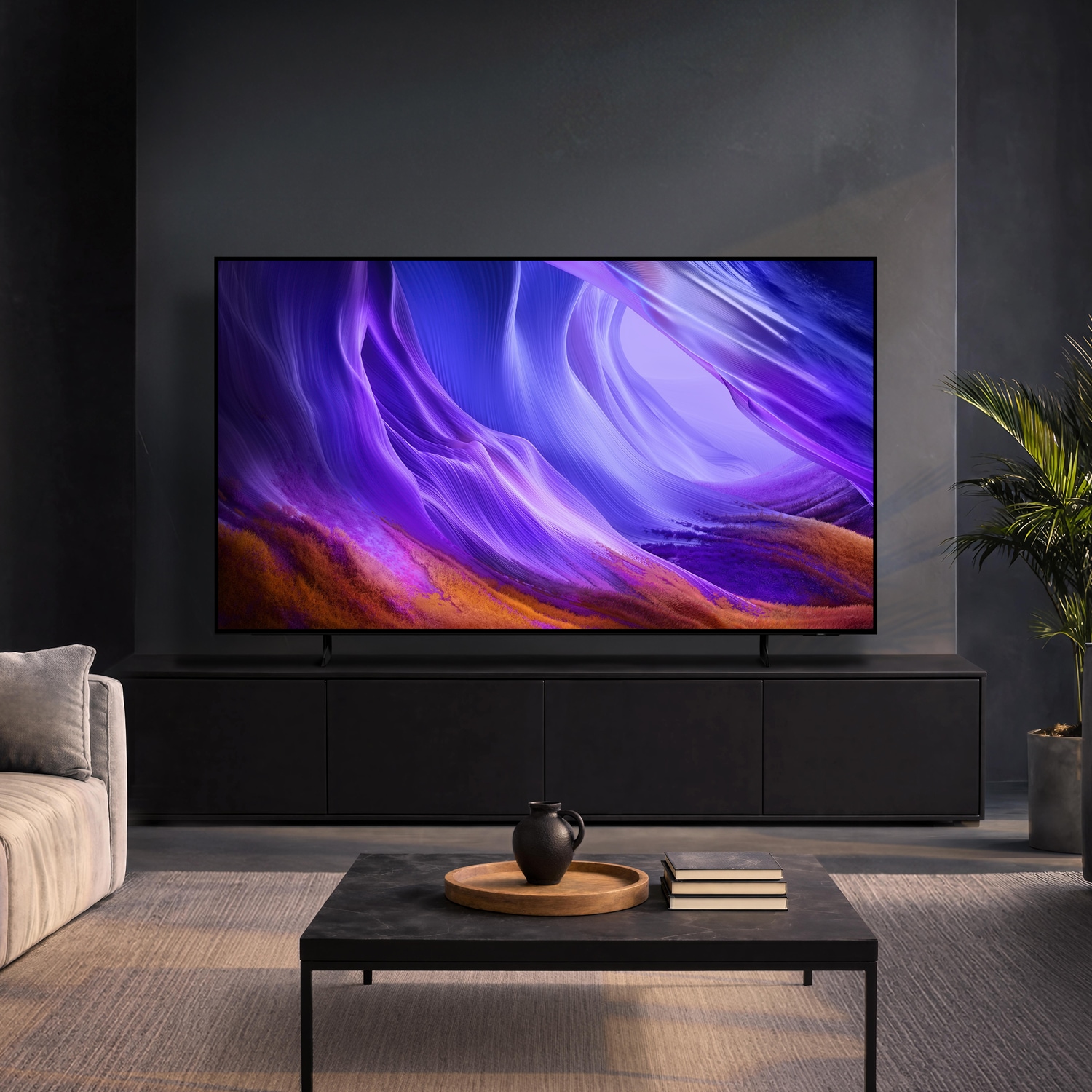 Samsung OLED‑TV i ett mörkt, modernt vardagsrum som visar livfulla lila abstrakta bilder som kompletterar den eleganta inredningen.