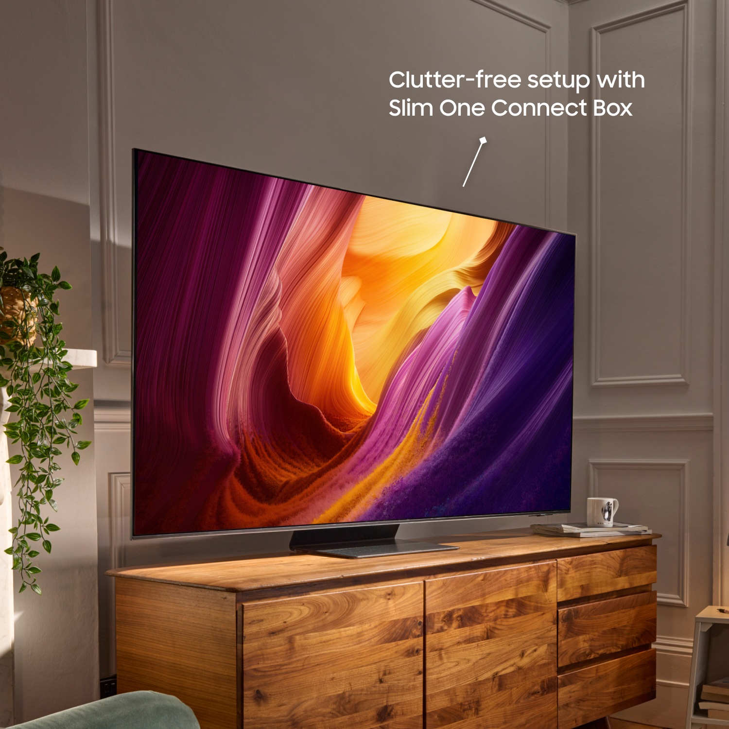 Elegant TV med livfull abstrakt bild, träkonsol och text som betonar en prydlig installation med Slim One Connect Box.