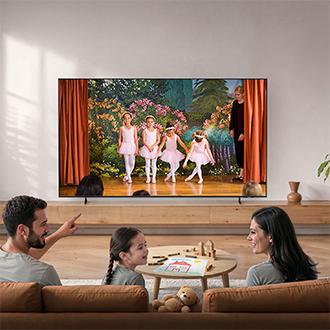 A family sits on a sofa watching a U7000H TV showing children performing a ballet recital, with toys and books scattered in a bright living room.