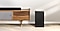 Samsung A series soundbar is being shown on top of a contemporary TV cabinet along with its matching subwoofer which is being displayed to the side of the TV cabinet.