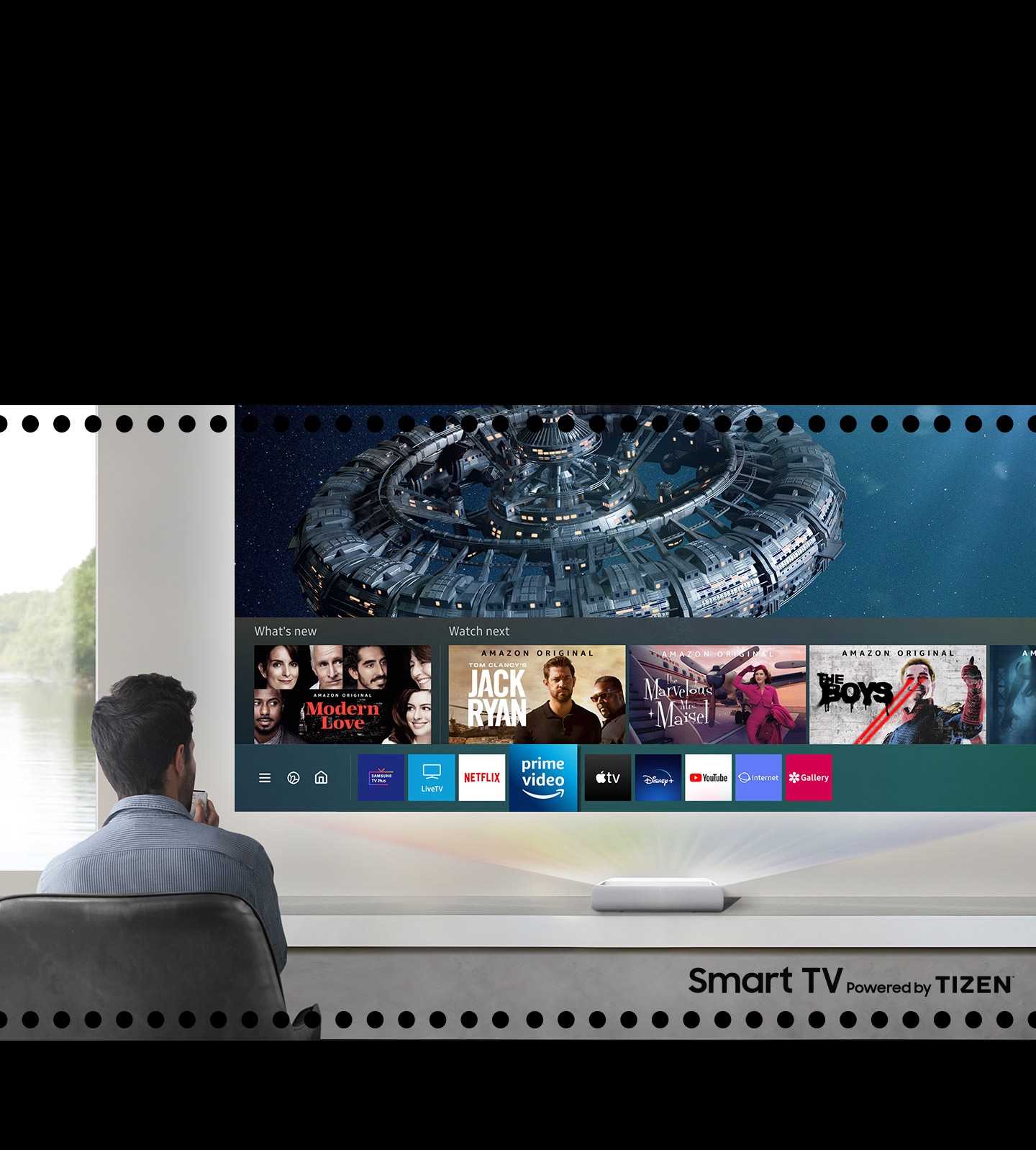 During use The Premiere, a man is considering what to see among the various contents like Samsung Smart TV recommended.