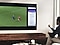 A man is using QLED's Multi view feature to enjoy a football match and view news on the same screen at the same time.