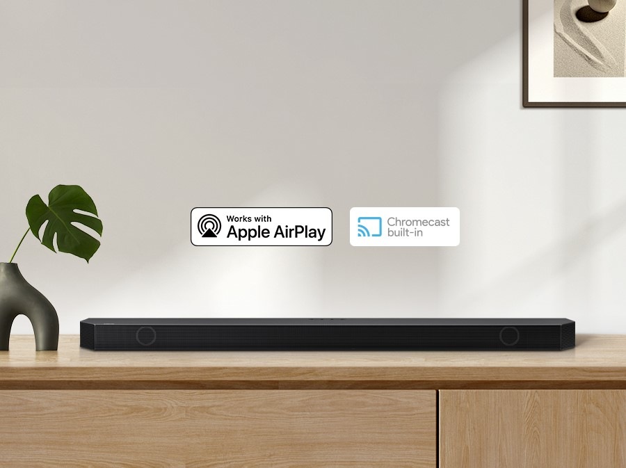 Логотип Alexa та Apple AirPlay можна побачити на звуковій панелі Samsung Q930B, яка встановлена ​​на шафі у вітальні.