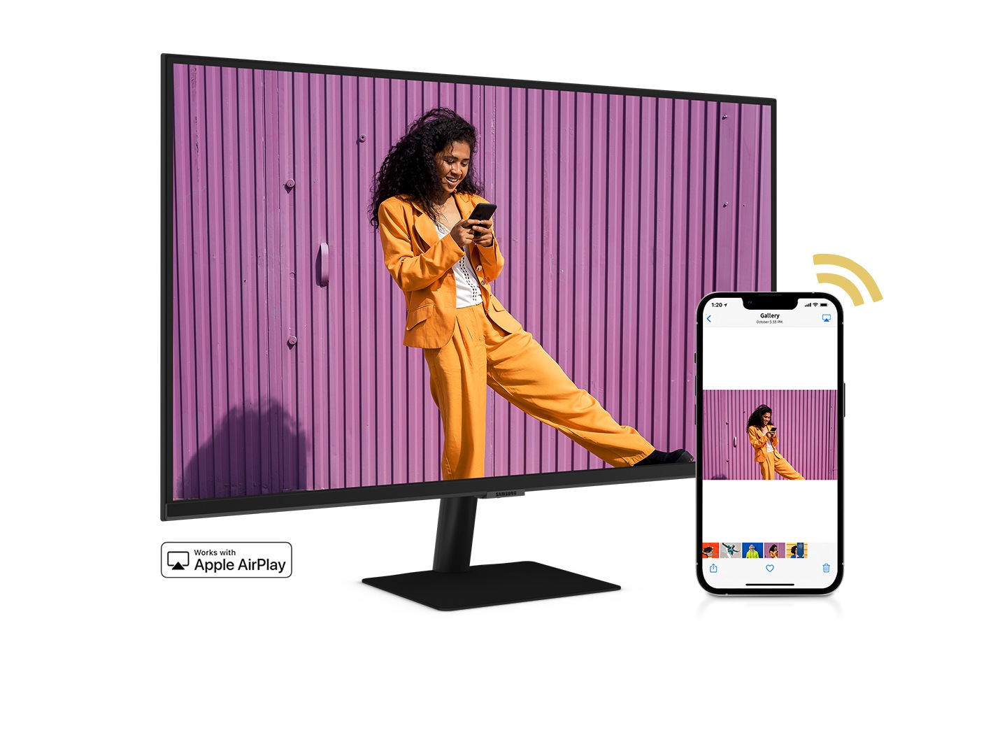 A smartphone and monitor sit side-by-side. The smartphone shows a woman posing with a skateboard. The same woman with skateboard is shown on the monitor. The smartphone's gallery app swipes through different photos which are also shown on the monitor screen.