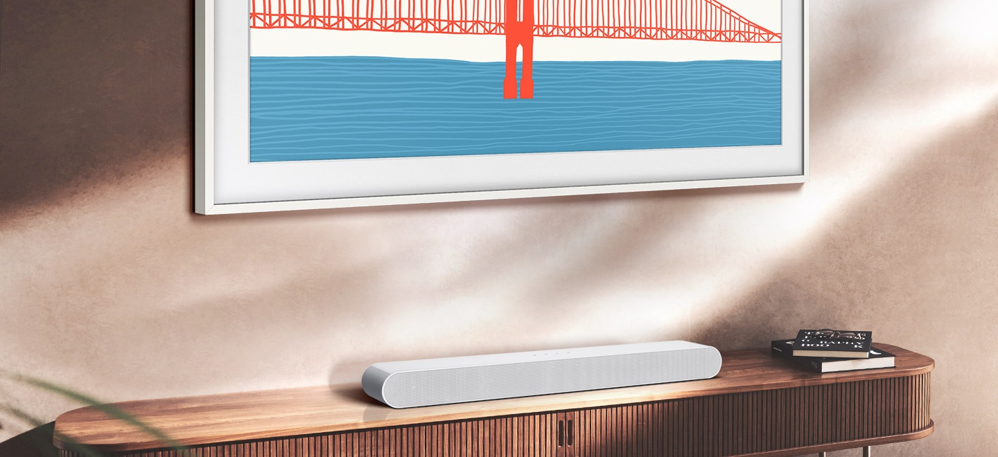 Samsung S61B Soundbar sitting on living room cabinet is positioned under The Frame TV.
