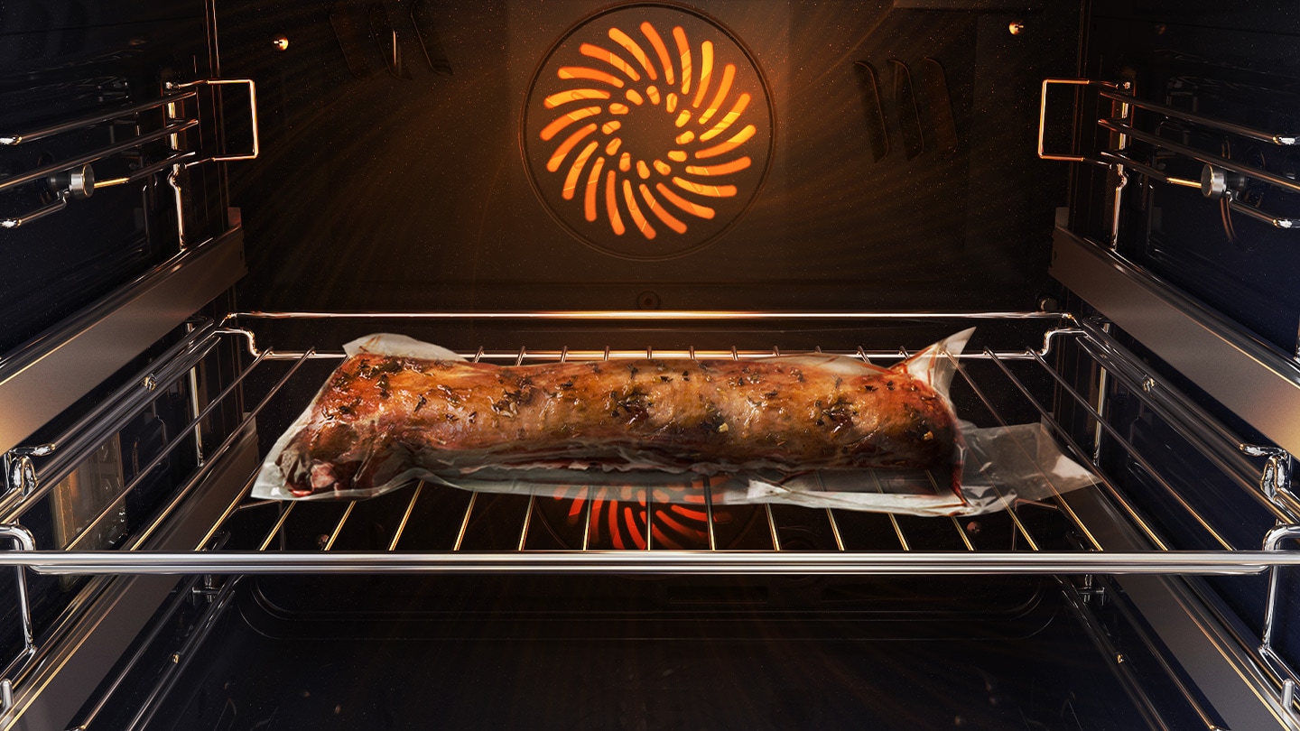 'Shows a joint of meat inside the oven, which is tightly sealed in a plastic bag and on a metal tray, being cooked using the Air Sous Vide system.