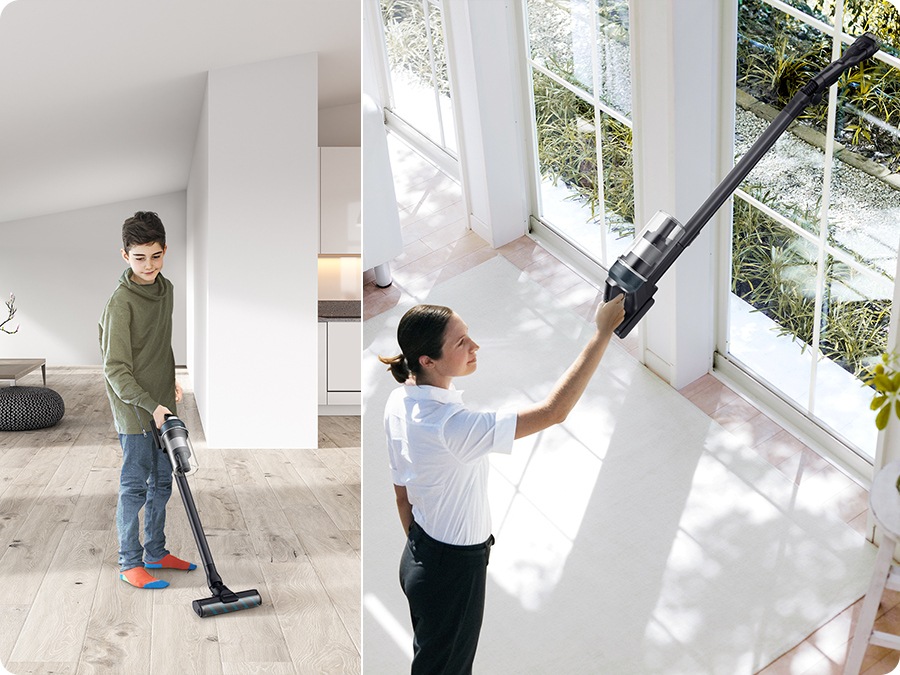 A young boy vacuums a living room with a Jet 85 and a woman vacuums a high window sill with a Jet 85.