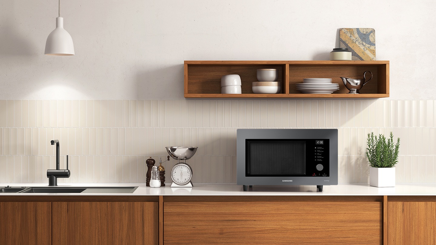 Shows the microwave oven on the counter top of a modern kitchen.