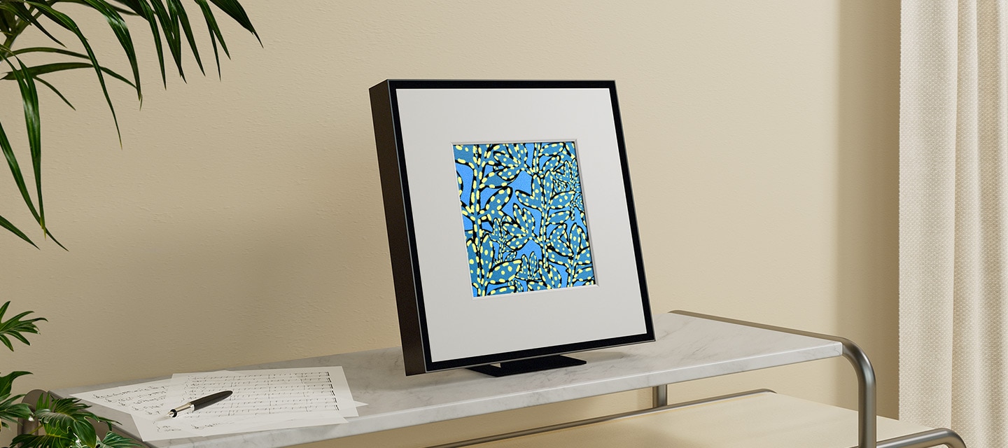 Music Frame displays an abstract blue vine pattern and is placed on top of a shelf.