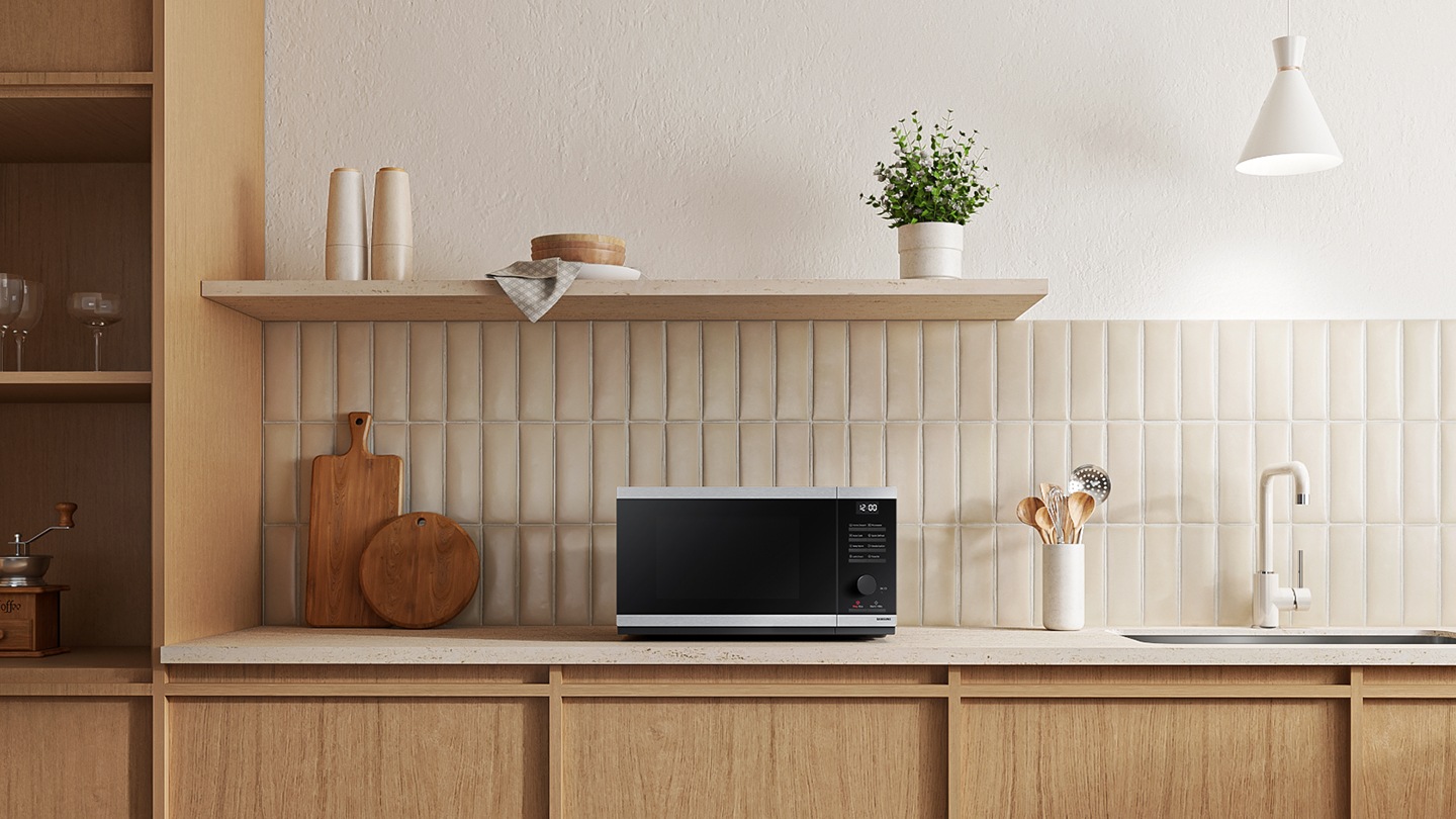 Shows the microwave oven on the counter top of a modern kitchen.