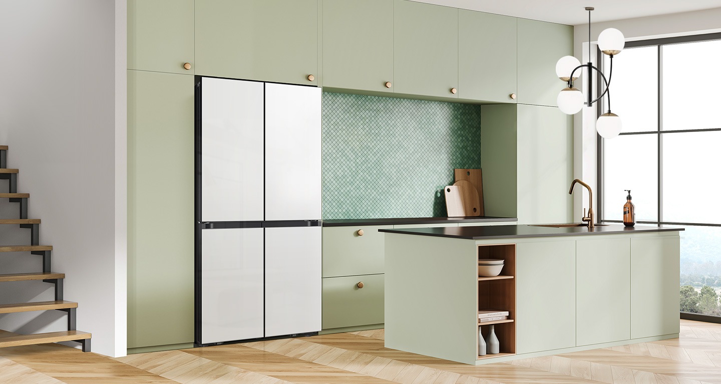 There is a french door Bespoke refrigerator in a sunlit contemporary kitchen with green cabinetry and a kitchen island.
