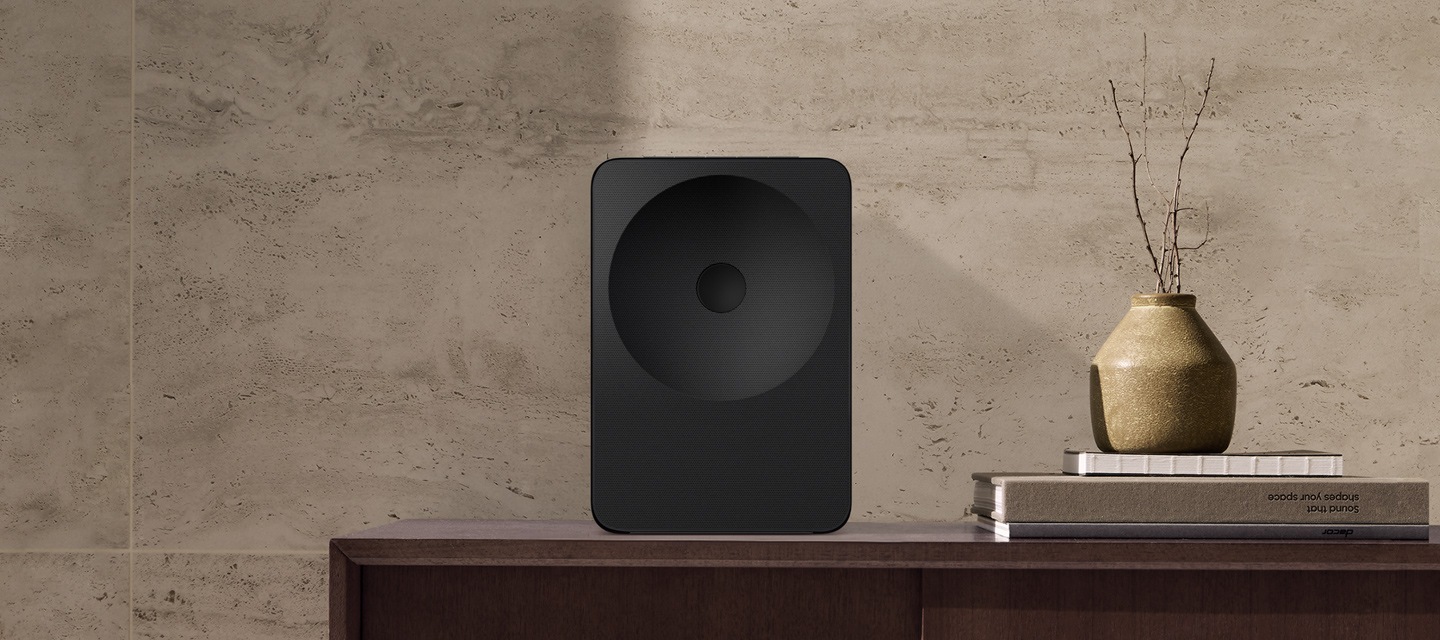 Music Studio 7 speaker shown on a stand and tabletop, highlighting its minimal geometry, smooth lines and calm, refined design presence.