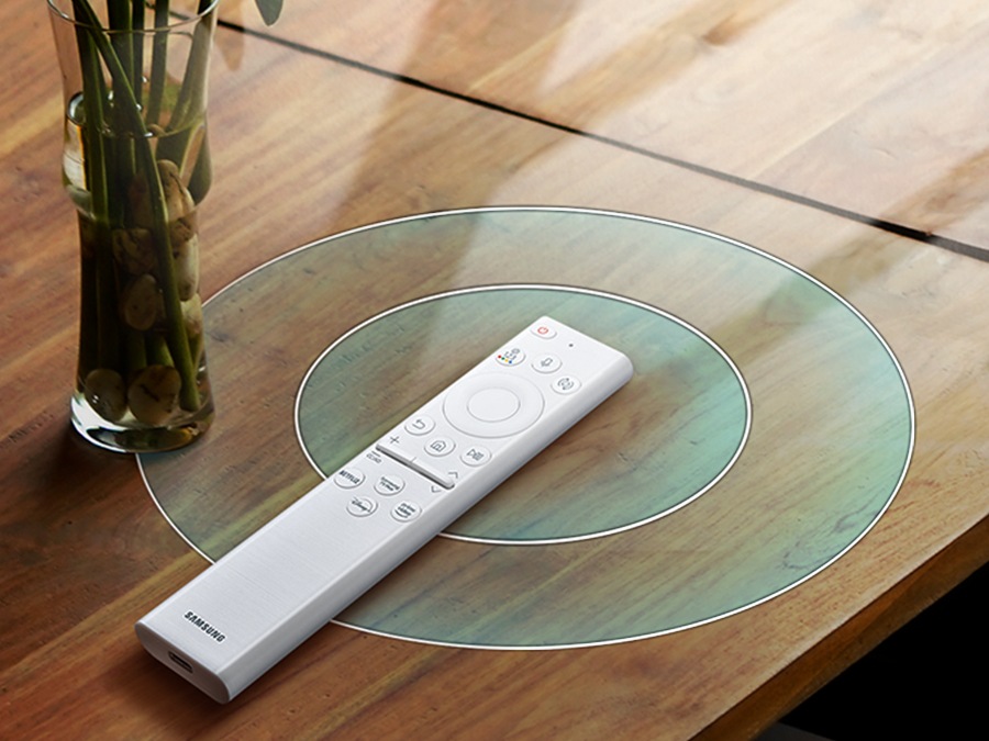 A SolarCell Remote is on a table next to a vase emitting signals in circular motion.