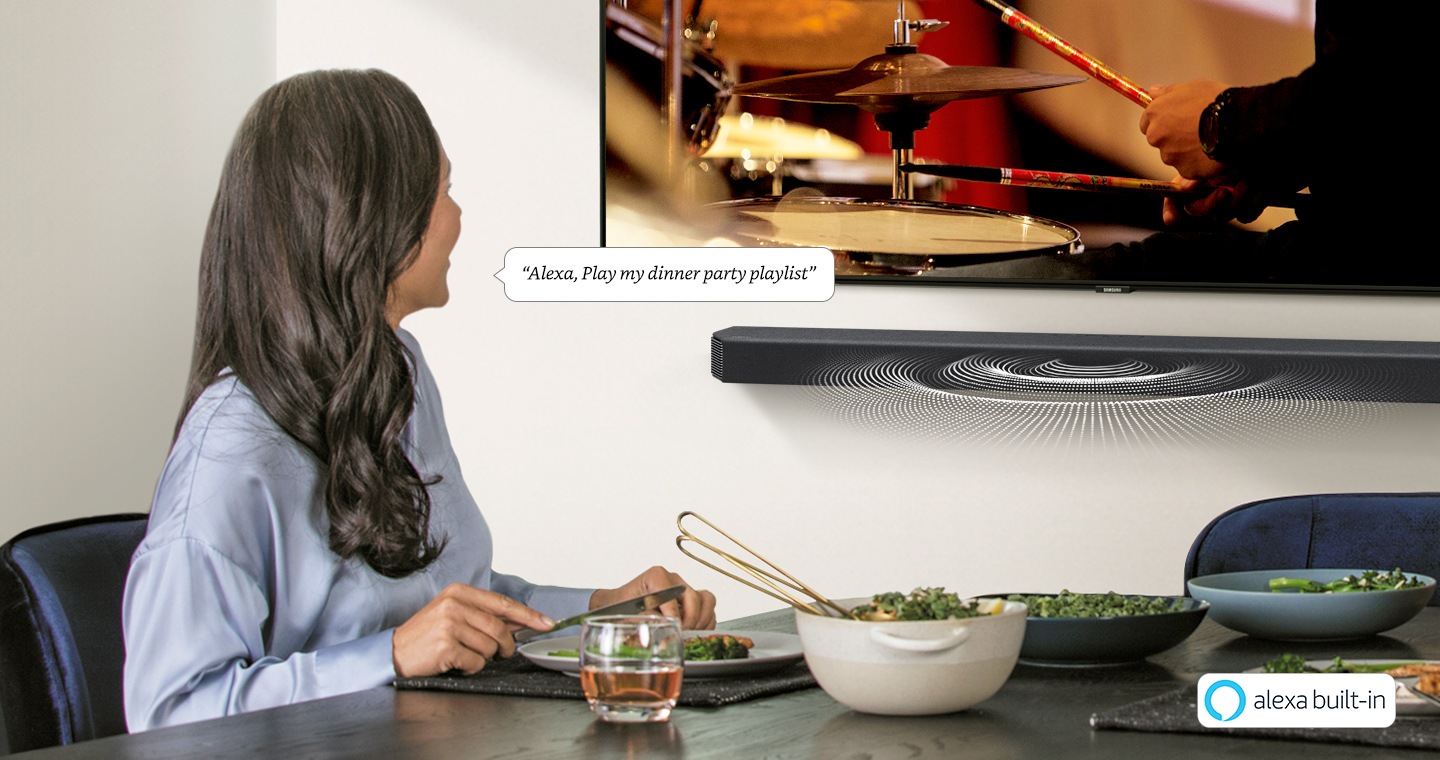 A woman uses Soundbar's built-in Alexa voice assistant and asks it to play her dinner party playlist.