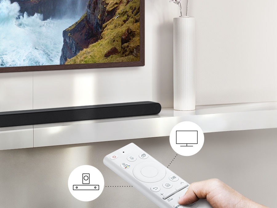 Uporabnik nadzoruje funkcije zvočne vrstice in TV-ja z daljinskim upravljalnikom za televizor Samsung.