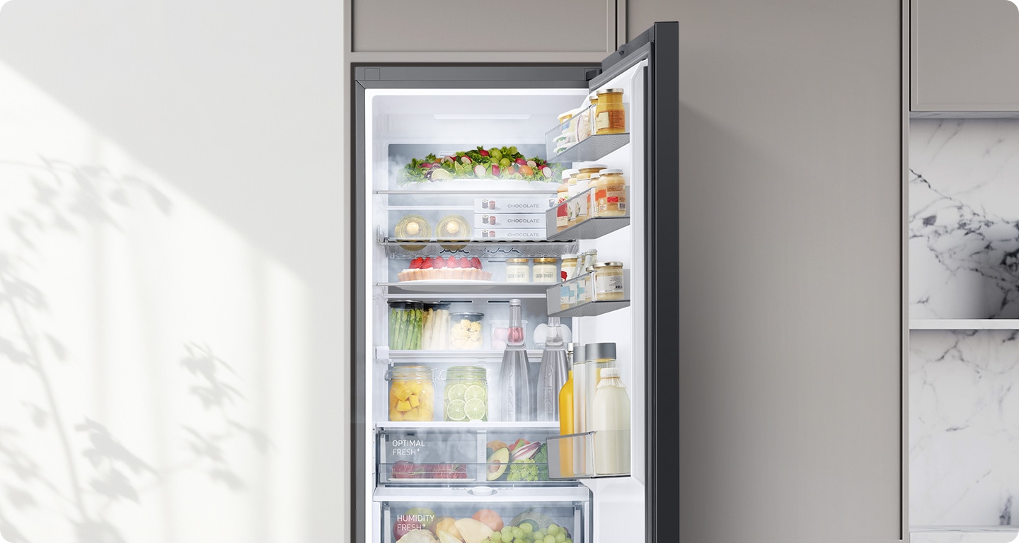 A Bespoke refrigerator filled with various foods is open. Cool air comes out through vents in each compartment to maintain the optimum temperature for the food to stay fresh.
