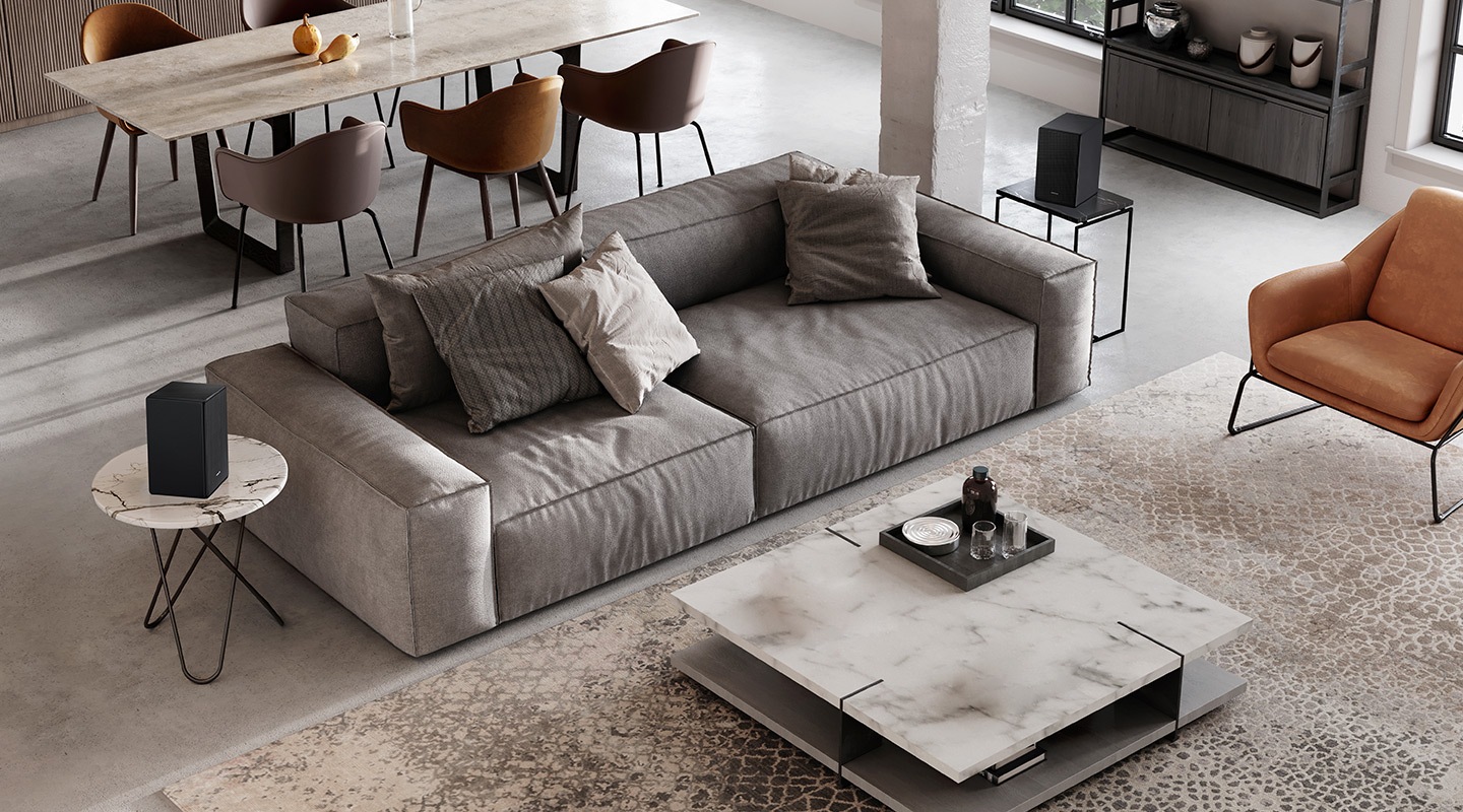 ภาพลำโพงหลัง SWA-9500S ทั้งสองตัวที่วางอยู่ข้าง ๆ โซฟาในห้องนั่งเล่นนั้นไม่ต้องใช้โมดูลไร้สายเพิ่มเติมในการเชื่อมต่อ