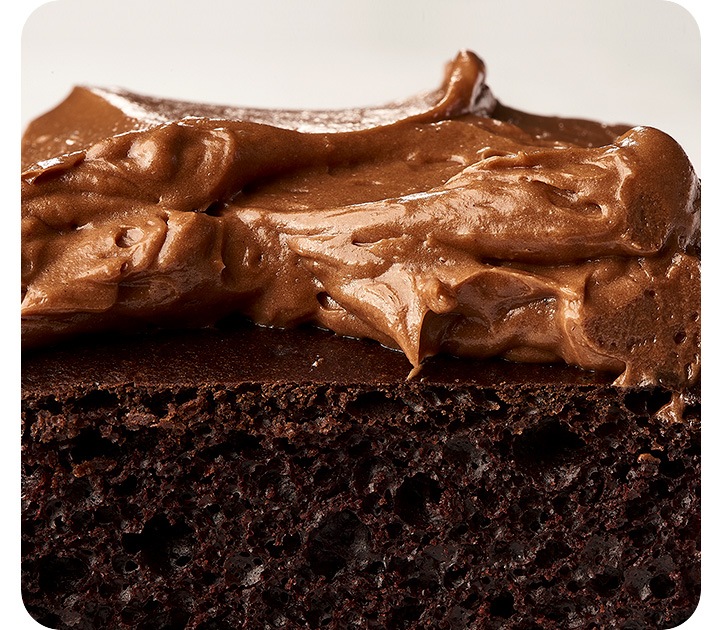 An extreme close-up the cross-section of a chocolate cake, showing the details of the cake's texture and the swirl of the frosting.