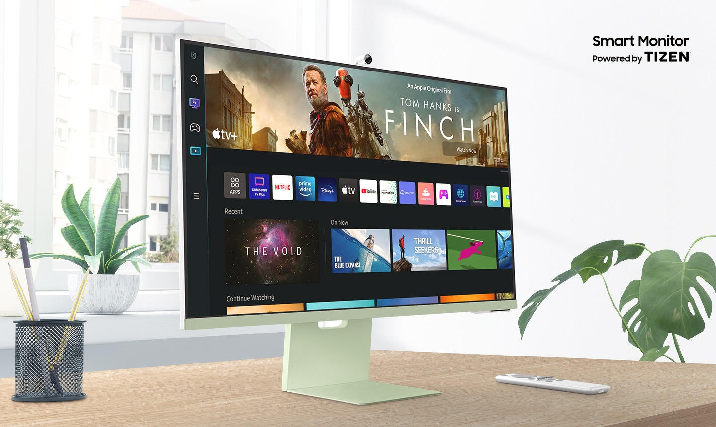 Samsung Smart Monitor M8 จอคอม สมาร์ททีวี 32 นิ้ว Smart TV ที่มาพร้อม Workmode โฉมใหม่ สามารถเข้าถึง PC อีกเครื่องได้จากระยะไกลได้. จอภาพตั้งอยู่บนโต๊ะไม้หน้า มีคำว่า Smart Monitor Powered by Tizen แสดงอยู่เหนือจอภาพ