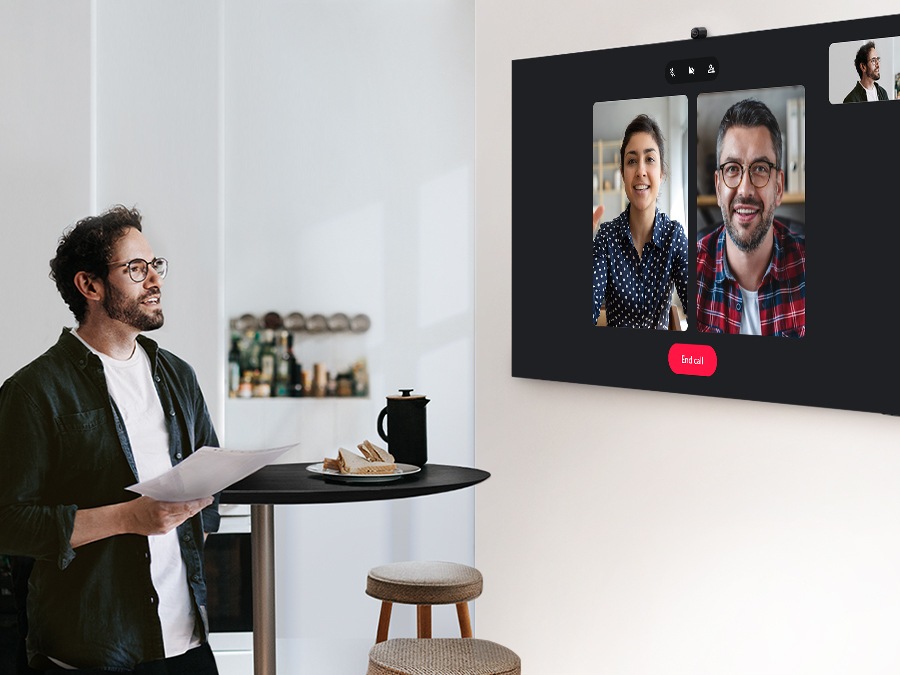 A man is having a video call with 2 other people via Google Duo. 