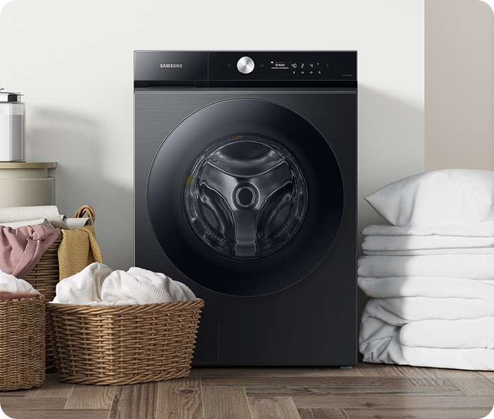 WD6000BK is in a laundry room. The baskets of laundry are placed to the left of the machine, and folded white bedding is placed to the right of the machine.