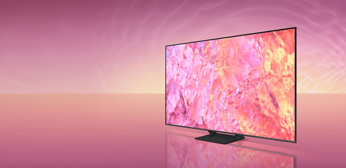 A QLED TV with a simple plus wide stand is displaying pink graphic on its screen.