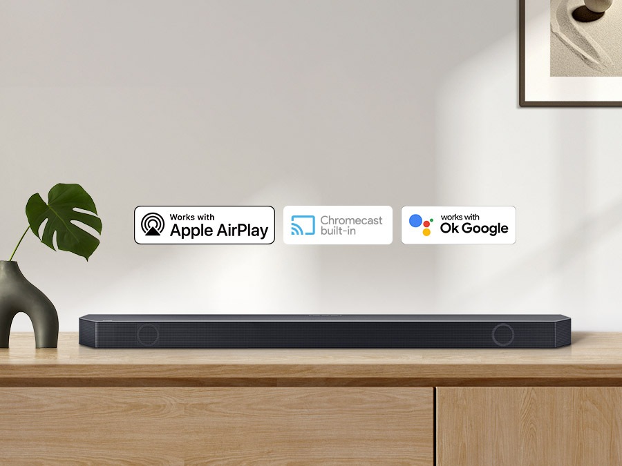 Chromecast built-in logo and Works with OK Google and Apple AirPlay logos with a Samsung Q series Soundbar.