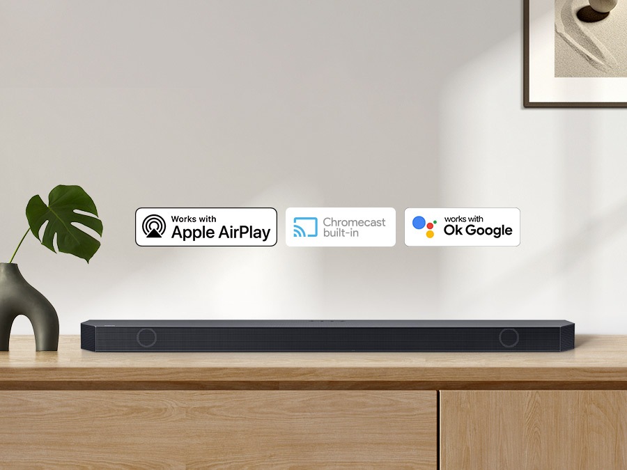 Chromecast built-in logo and Works with OK Google and Apple AirPlay logos with a Samsung Q series Soundbar.