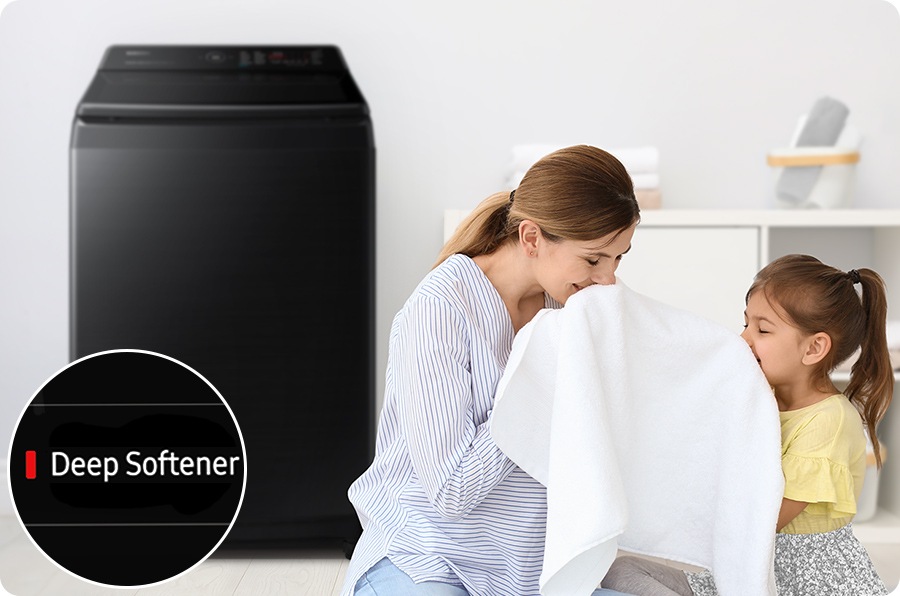 Next to the washing machine, a woman and her daughter are sniffing towels, washing towels using the Delay End course's Deep Softener.