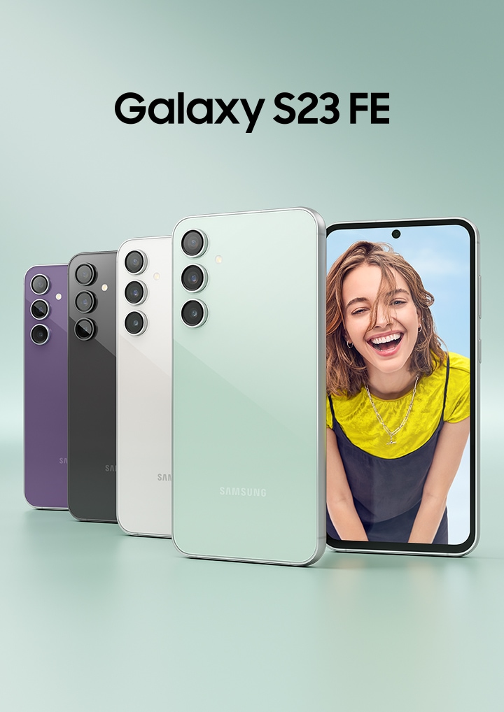 โทรศัพท์ Galaxy S23 FE ห้าเครื่อง สี Purple, Graphite, Cream และ Mint โดยที่สี่เครื่องนั้นวางตั้งเครื่องหันด้านหลังให้และซ้อนทับกันอยู่ ส่วนอีกเครื่องหนึ่งหันด้านหน้าให้พร้อมกับมีรูปผู้หญิงคนหนึ่งยิ้มให้กล้องแสดงอยู่ในหน้าจอ