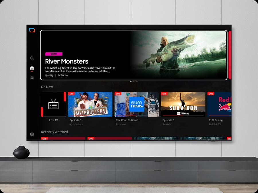 ทีวีในห้องนั่งเล่นจะแสดงหน้าจอหลักของ Samsung TV Plus และช่องทีวีต่างๆ ที่มีมาให้
