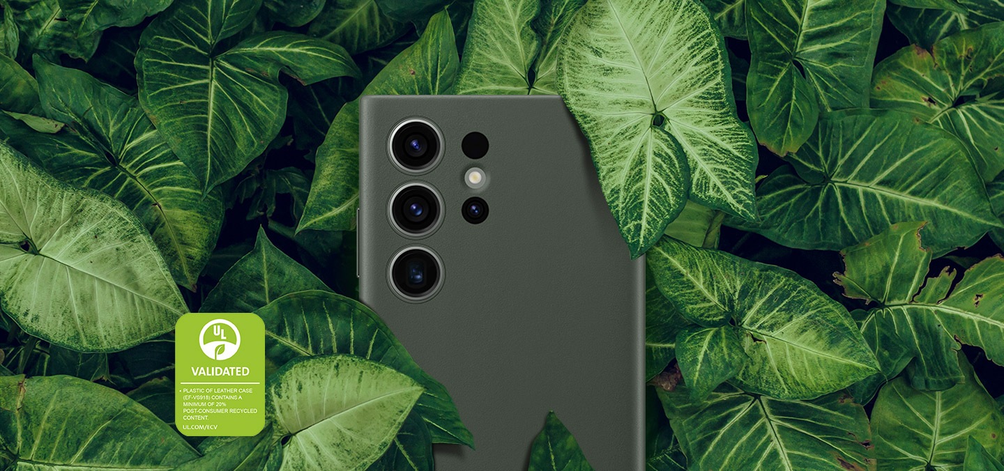 Deri Kılıf takılı bir Galaxy S23 Ultra cihazın arkası, kalın yeşil yapraklarla çevrili olarak gösteriliyor. Metinde, DERİ KILIFIN (EF-VS918) PLASTİĞİ, EN AZ %20 ORANINDA “TÜKETİM SONRASI GERİ DÖNÜŞTÜRÜLMÜŞ MALZEME” İÇERİR yazıyor.