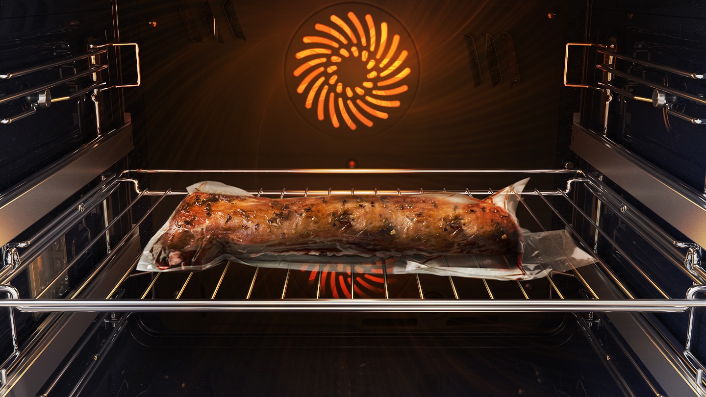 Shows a joint of meat inside the oven, which is tightly sealed in a plastic bag and on a metal tray, being cooked using the Air Sous Vide system.