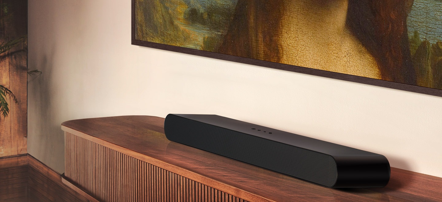 Samsung S series Soundbar and subwoofer are positioned with Samsung TV on living room cabinet.