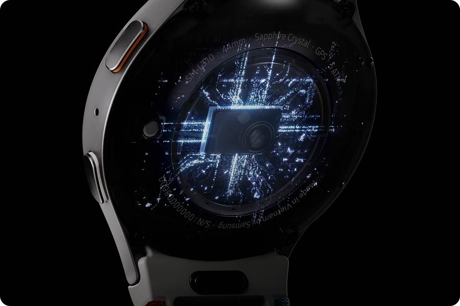 Arkadan görülen bir Galaxy Watch7’nin işlemcisi elektrik akımı görseliyle birlikte gösteriliyor. Ardından saat dönüyor ve zamanı gösteren ekranı, “Energy Score’um” ekranını ve “Günlük Aktivite” ekranını teker teker gösteriyor.