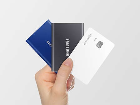 Bir ki�i elinde Samsung T7 ve bir kredi kart� tutuyor. Her ikisinin de benzer boyutlarda oldu�u g�r�l�yor.