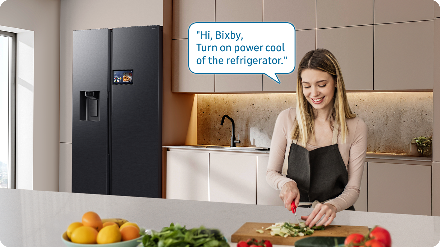 Samsung Bixby kullanarak buzdolabını kontrol ederken yemek hazırlayan bir kişiyi gösteriyor. “Merhaba Bixby, buzdolabının Power Cool özelliğini aç.”