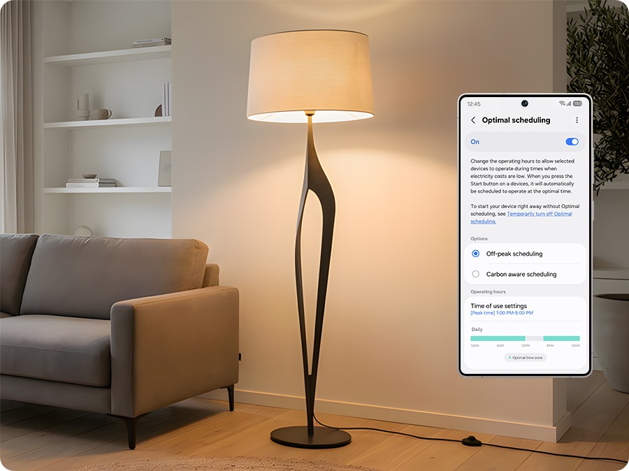 A modern living room with a standing lamp and sofa. On the SmartThings app screen, Optimal Scheduling is turned On, showing the settings for Off-Peak Scheduling and Carbon-Aware Scheduling separately.