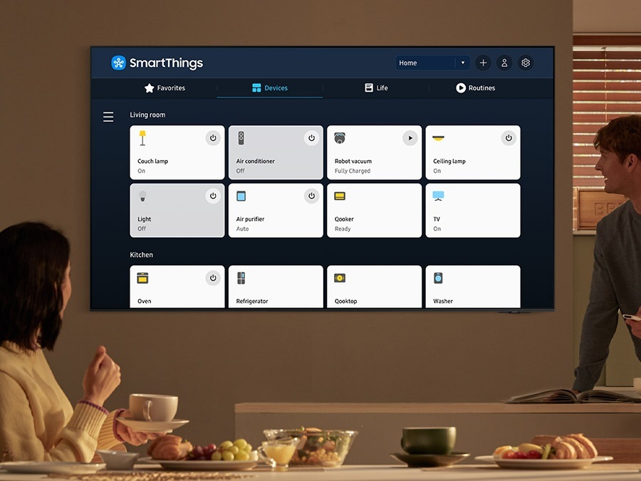 TV'de dahili hub'ına çeşitli "Oturma odası" ve "Mutfak" cihazları bağlı olan SmartThings uygulaması gösteriliyor.